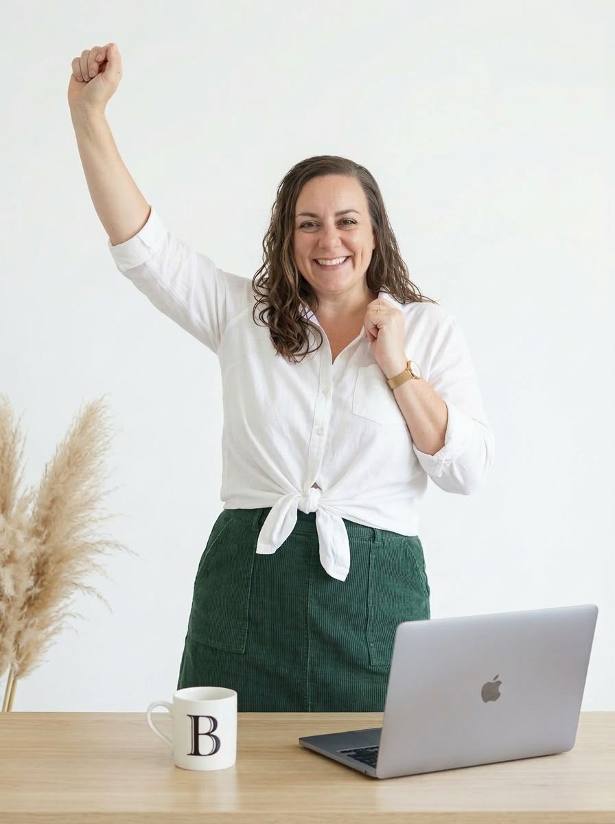 Brenda celebrating with a fist in the air at her desk — what it feels like when your business finally runs on systems.